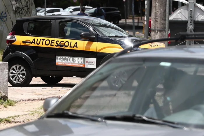 Instrutores de trânsito autônomos em veículo de autoescola durante aula prática de direção