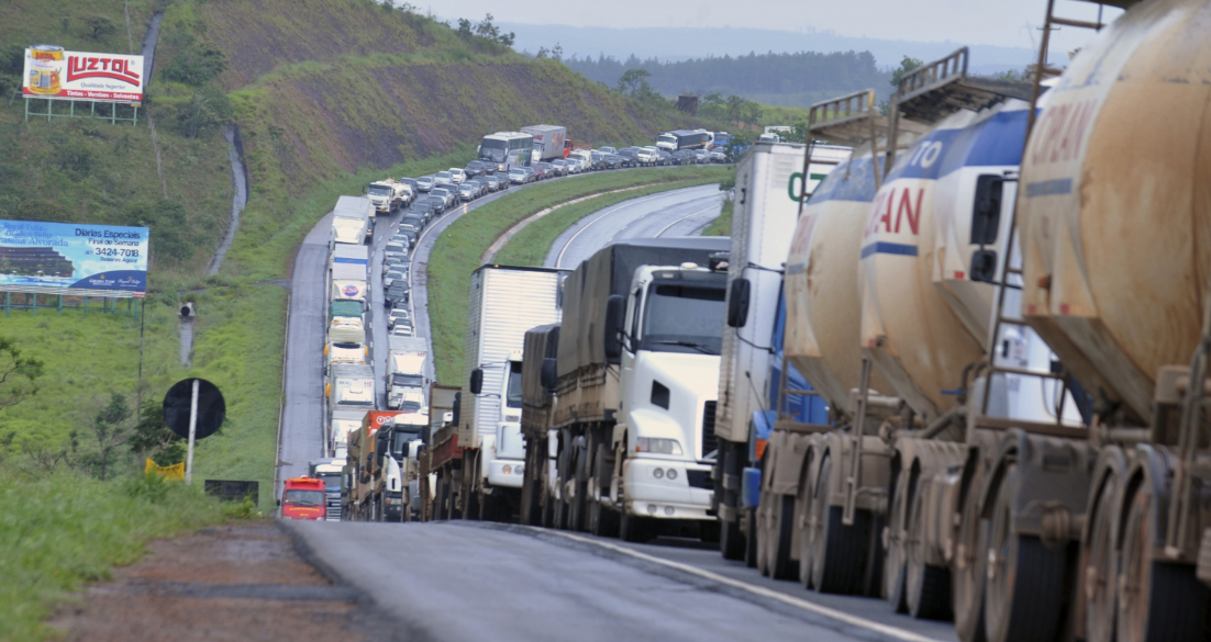 greve de caminhoneiros com longa fila de caminhões parados em rodovia no Brasil
