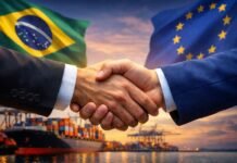 O que muda no Brasil com o acordo Mercosul–União Europeia Aperto de mãos simboliza acordo comercial entre Brasil e União Europeia com porto de contêineres ao fundo
