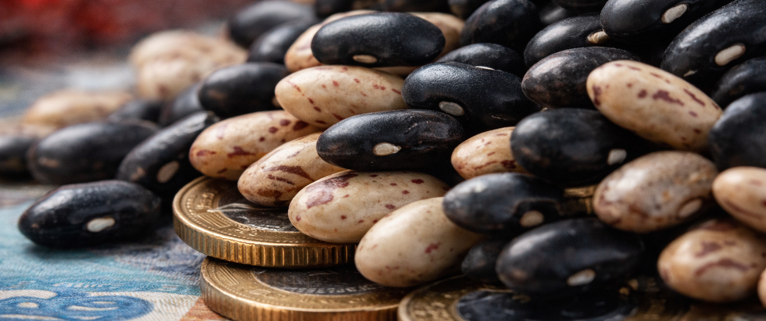 Feijão em macro sobre moedas representa pressão da cesta básica