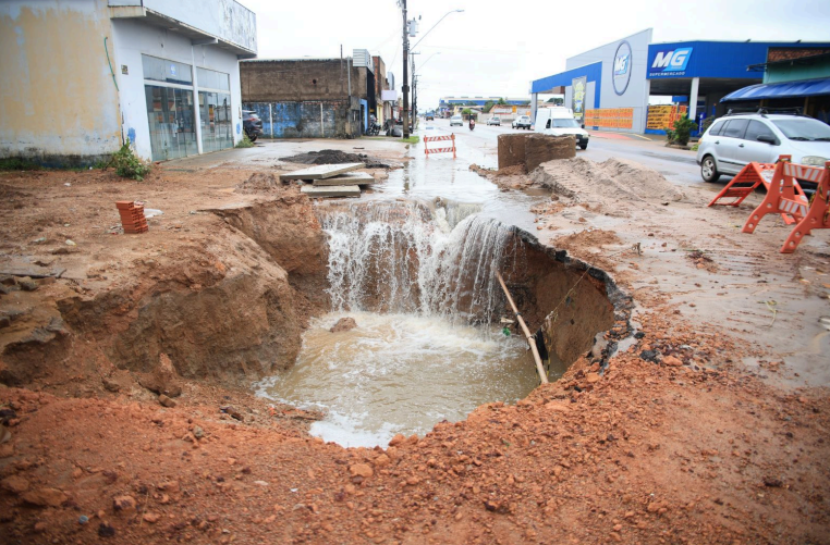 Buraco na rua com água acumulada.