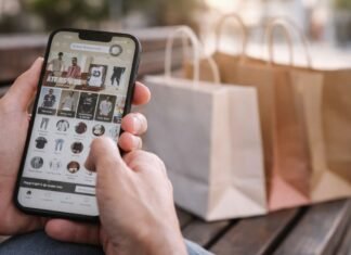 Lula critica taxa das blusinhas e prepara pacote econômico Consumidor segura celular com tela de compra online enquanto sacolas aparecem ao fundo, em referência à taxa das blusinhas.