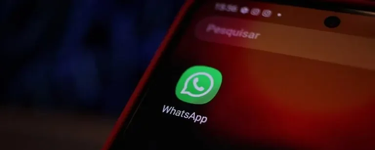 Ícone do WhatsApp em tela de celular com foco em aplicativo e ambiente escuro