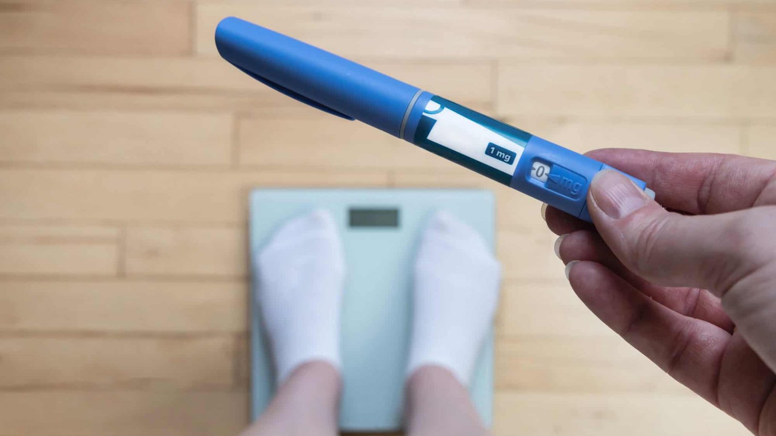 Caneta emagrecedora em primeiro plano com balança ao fundo durante tratamento para perda de peso