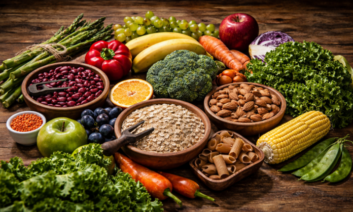 Fibra e proteína em alimentos saudáveis dispostos sobre mesa de madeira