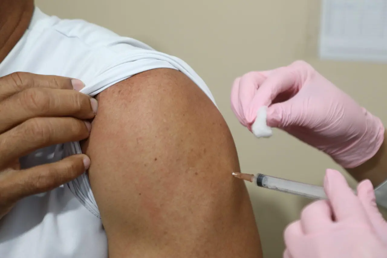 Aplicação de vacina em braço exposto.