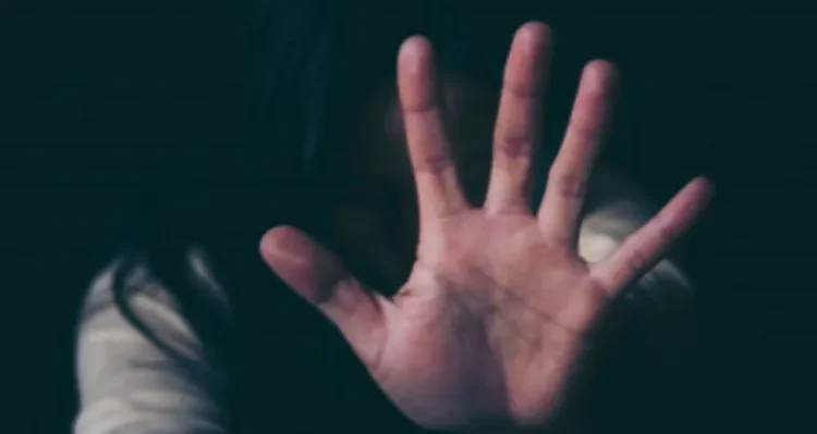 Mulher faz gesto de defesa com a mão em imagem que representa violência doméstica