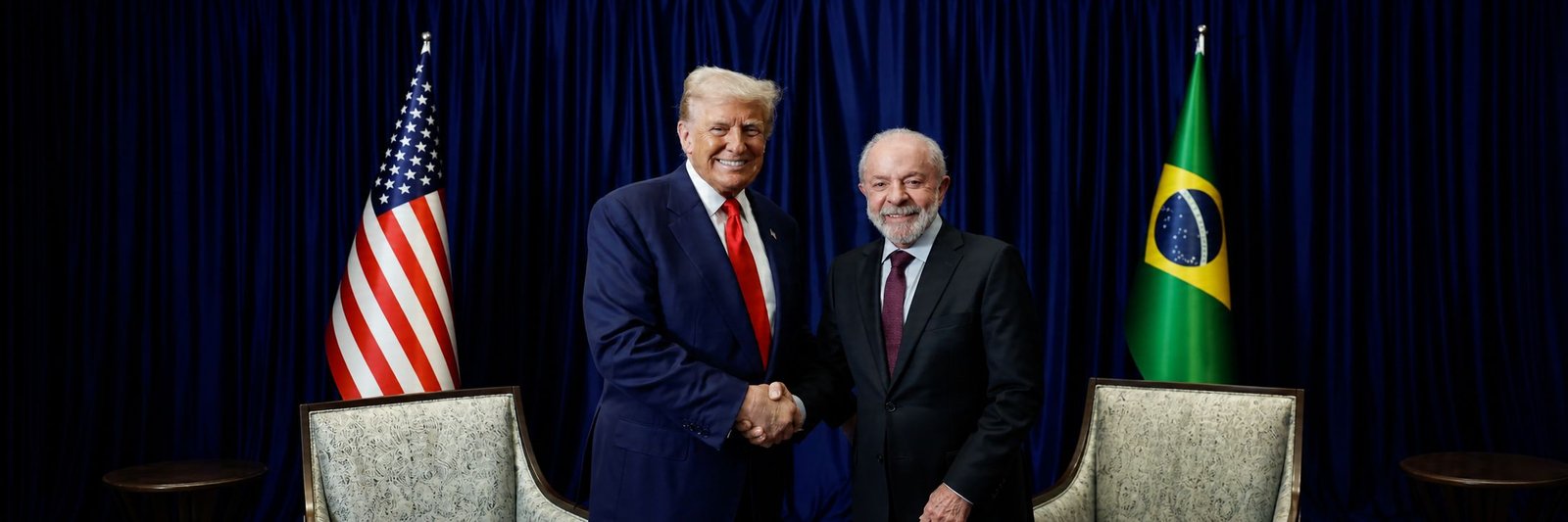 Lula e Trump em encontro diplomático com bandeiras dos Estados Unidos e do Brasil ao fundo