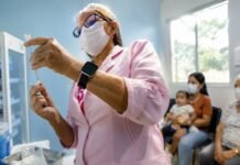 Central de vacinas em Porto Velho já aplicou 614 doses especiais Profissional de saúde prepara dose na central de vacinas em Porto Velho com pacientes aguardando atendimento especial