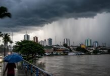 Fim de semana terá alerta de chuva no Norte e instabilidade no país Chuva no Norte com nuvens carregadas sobre área urbana às margens de rio durante alerta de fim de semana