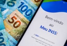 INSS exige biometria facial e muda regras do consignado para aposentados Celular com aplicativo Meu INSS sobre cédulas de dinheiro, representando novas regras do empréstimo consignado do INSS.