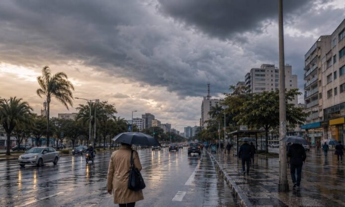Frente fria no Brasil provoca chuva e queda de temperatura Frente fria no Brasil provoca chuva em avenida urbana com pessoas usando guarda-chuvas e céu nublado