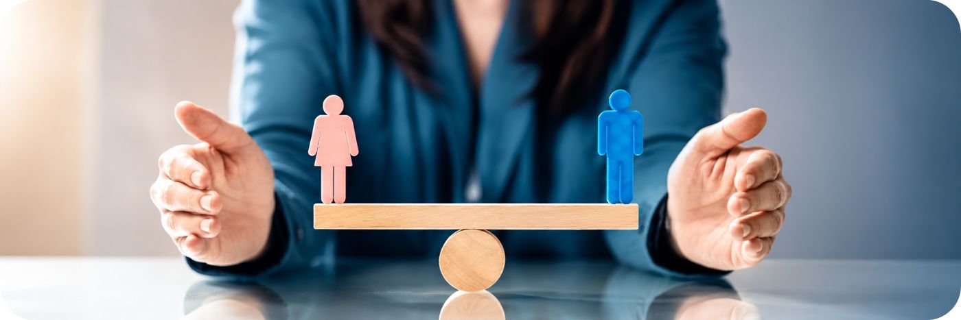 Balança de madeira com figuras masculina e feminina simbolizando igualdade salarial entre homens e mulheres