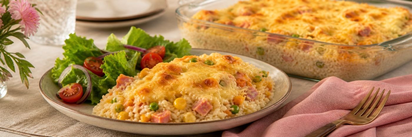 Porção de arroz de forno para o Dia das Mães servida com salada verde e travessa ao fundo
