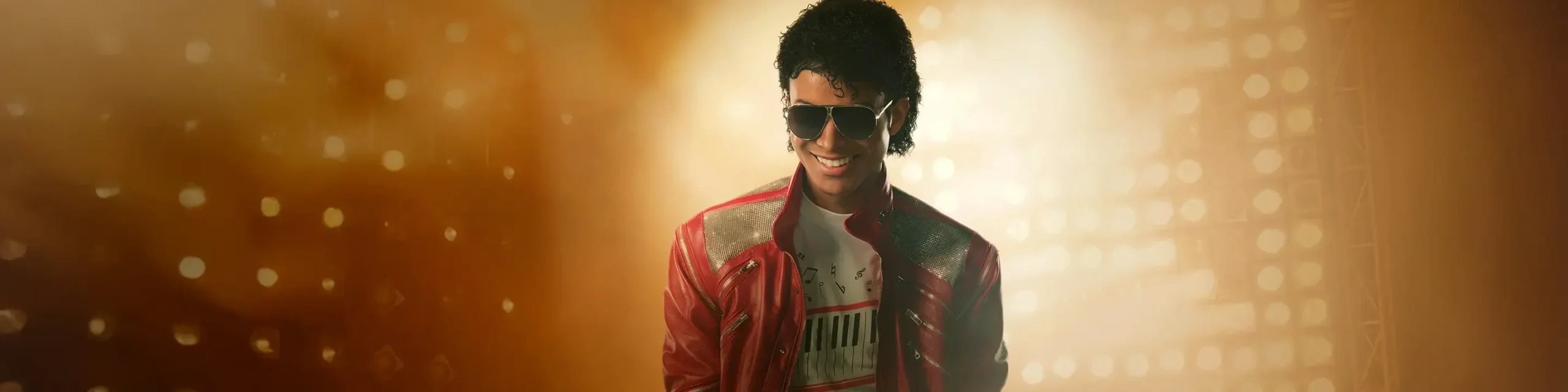 Michael no streaming com Jaafar Jackson em cena de jaqueta vermelha