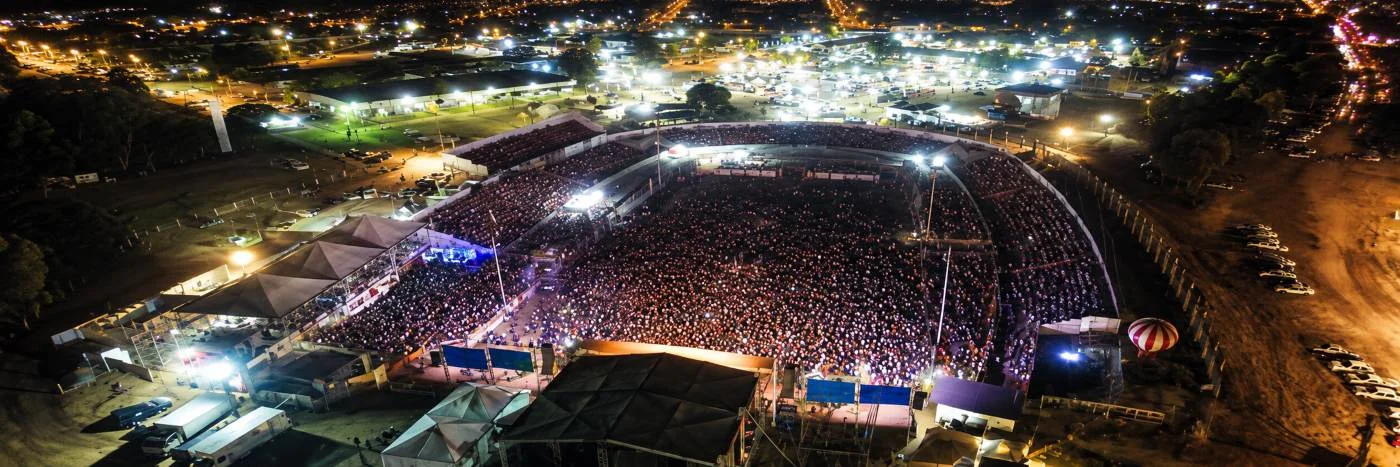 Vista aérea noturna mostra grande público em parque de exposições durante evento da Expojipa em Ji-Paraná.