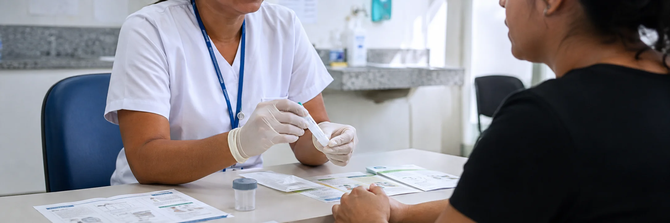 Teste FIT com profissional de saúde orientando paciente sobre coleta para rastreamento do câncer de intestino