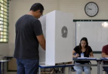 Eleições 2026: Rondônia terá votação das 7h às 16h Eleitor vota em seção eleitoral de Rondônia com relógio ao fundo indicando o horário de votação