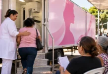Carreta fará mamografias sem agendamento no Areal por três manhãs Cena ilustrativa de profissional acolhendo mulher na entrada de uma unidade móvel de mamografia em Porto Velho