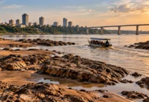 Defesa Civil reforça alerta para navegação no Rio Madeira Imagem ilustrativa da navegação no Rio Madeira com embarcação entre bancos de areia e pedras expostas