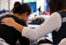 Curso gratuito ensina apoio em saúde mental durante emergências e desastres Profissional acolhe pessoa em ambiente de apoio sobre saúde mental em desastres