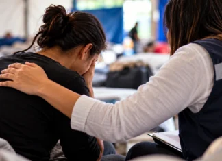 Curso gratuito ensina apoio em saúde mental durante emergências e desastres Profissional acolhe pessoa em ambiente de apoio sobre saúde mental em desastres