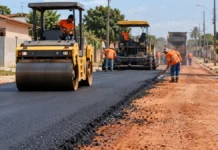 Novo Horizonte do Oeste tem 1,3 km asfaltados e mais 1.229 metros em preparação Asfalto em Novo Horizonte do Oeste ilustrado por obra de pavimentação urbana, com rolo compactador e trabalhadores.