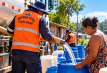 Defesa Civil já entregou mais de 180 mil litros e prepara ações no Baixo Madeira Distribuição de água em Porto Velho representada por imagem ilustrativa de trabalhador abastecendo recipiente azul com caminhão-pipa durante a estiagem.