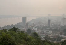 Queimadas no Amazonas levam fumaça a Porto Velho e aumentam riscos à saúde Vista ilustrativa da cidade com céu esbranquiçado pela poluição atmosférica, representando a fumaça em Porto Velho associada às queimadas no Amazonas.