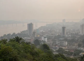 Queimadas no Amazonas levam fumaça a Porto Velho e aumentam riscos à saúde Vista ilustrativa da cidade com céu esbranquiçado pela poluição atmosférica, representando a fumaça em Porto Velho associada às queimadas no Amazonas.