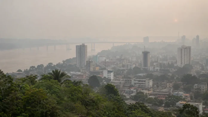 Fumaça encobre o horizonte urbano de Porto Velho Vista ilustrativa da cidade com céu esbranquiçado pela poluição atmosférica, representando a fumaça em Porto Velho associada às queimadas no Amazonas.
