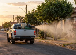 Vilhena aplica fumacê em sete bairros; confira as áreas atendidas Veículo de fumacê em Vilhena representado em cena ilustrativa de aplicação de inseticida em rua residencial.
