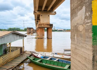 Defesa Civil alerta para bancos de areia e encalhamentos no Rio Madeira Composição visual baseada em fotografia fornecida pelo editor mostra o nível do Rio Madeira, régua fluviométrica, ponte e embarcações em Porto Velho.