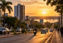 Semusa abre concurso com 641 vagas imediatas; salários chegam a R$ 9,8 mil Paisagem urbana ao entardecer com avenida movimentada e rio ao fundo