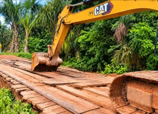 Porto Velho programa recuperação de cinco pontes rurais Escavadeira sobre ponte de madeira em estrada rural, em imagem editorial sobre pontes rurais em Porto Velho.